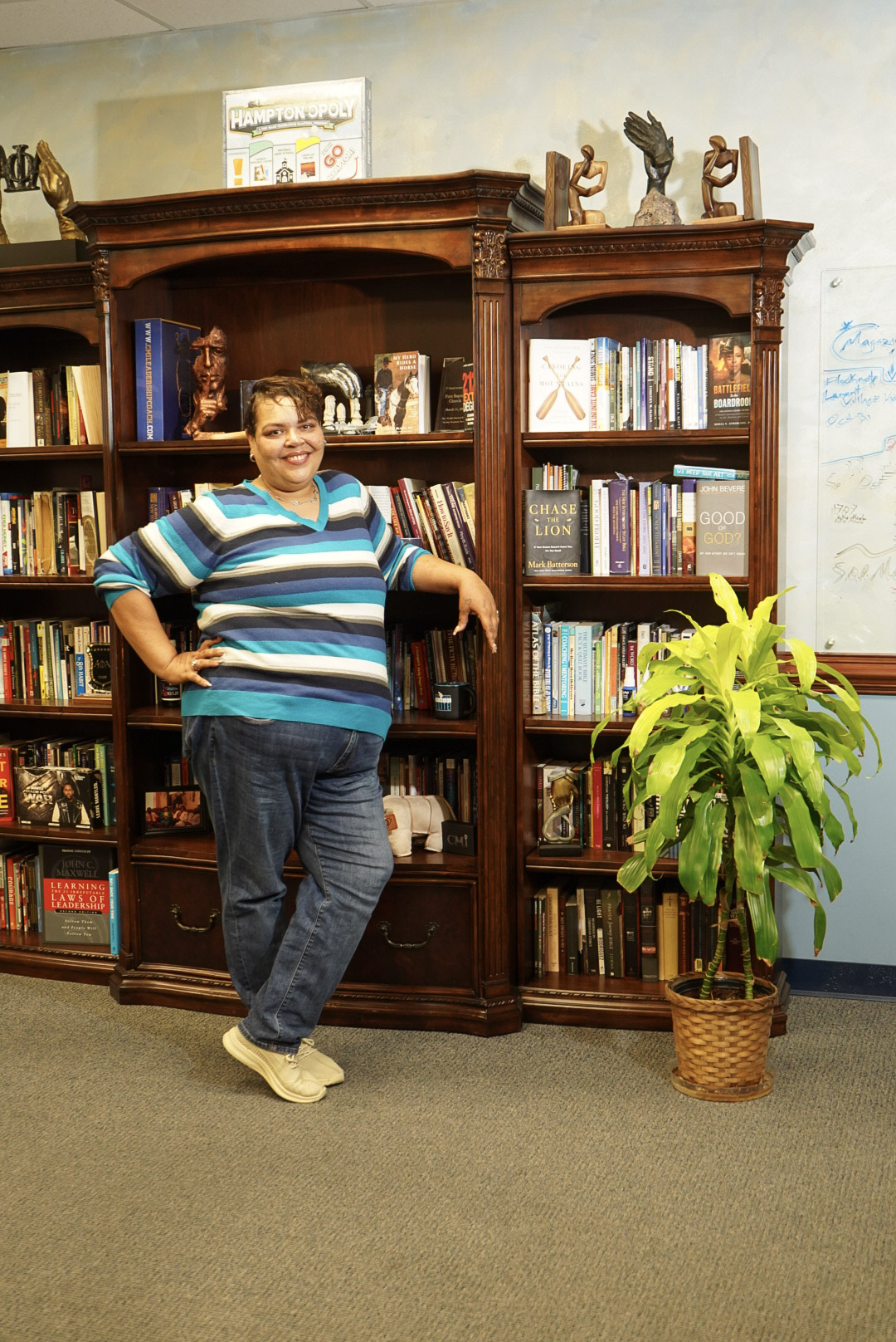 Eliza Herbert smiling beside a bookcase full of books